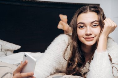 güzel uzun saçlı kız yatakta yatıyor erken sabah, gülümsüyor, kameraya, Günaydın görünüyor