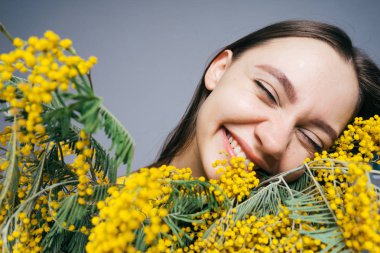 mutlu gülen genç kız güzel kokulu sarı Mimoza burnunu çekmek