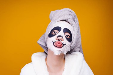bir havlu başında, yüzünde resmi bir panda bir namlu olan yararlı bir maske ile genç kız