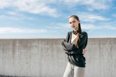 Kendine güvenen şık kız açık havada egzersiz yaptıktan sonra dinlenme mavi gökyüzü altında poz