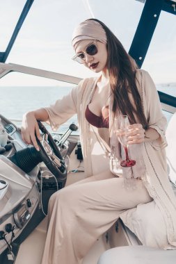 bir lüks şık kız zengin bir hayat sahiptir ve şampanya içer, onun beyaz yatta yelken