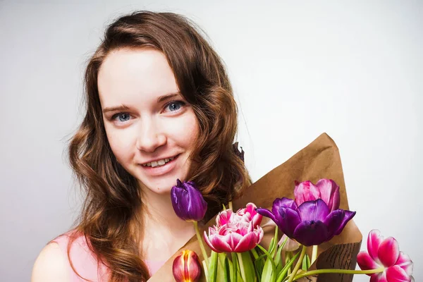 Mooi blij meisje houdt van een groot boeket van geurige bloemen, viert Moederdag — Stockfoto