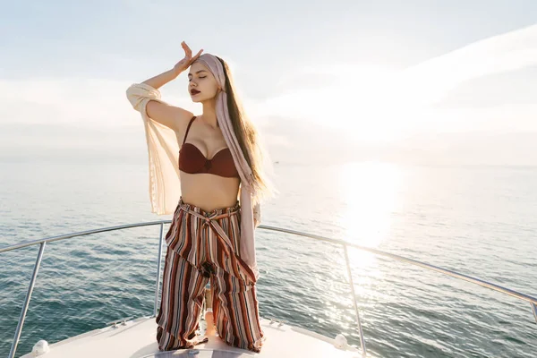 Luxurious attractive girl in stylish clothes posing on her white yacht, sailing on the Caribbean islands — Stock Photo, Image