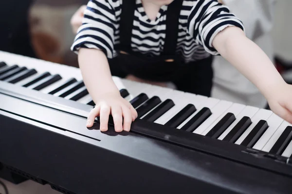 Famille amicale, petit garçon jouant du piano, étudiant le monde — Photo