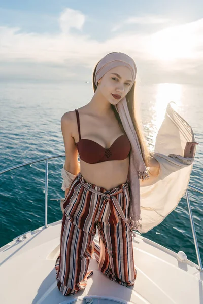 Luxuriöse stilvolle Mädchen steht auf einer weißen Jacht, segelt zu den karibischen Inseln und posiert, Urlaub — Stockfoto