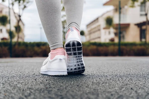 Flickan går i för sport, tåg utomhus i sneakers — Stockfoto