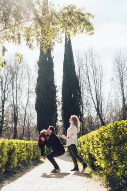 mutlu dostu aile, kıvırcık anne ve baba ile küçük oğulları parkta oynarken