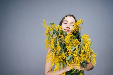 güzel genç kız bahar hava sahiptir, sarı Mimoza büyük bir buket tutar