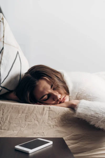 Una joven se acuesta en la cama, duerme temprano en la mañana y no quiere entrar —  Fotos de Stock