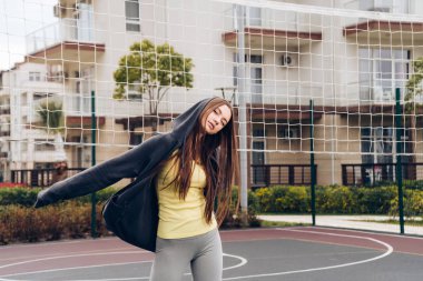 Kendine güvenen atletik kız trenler bir spor zemin üzerinde aktif bir yaşam tarzı yol açar