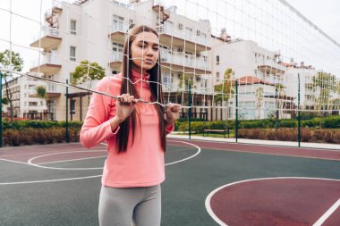 bir spor alan açık havada, tarafından net ayakta üzerinde egzersiz emin ince kız