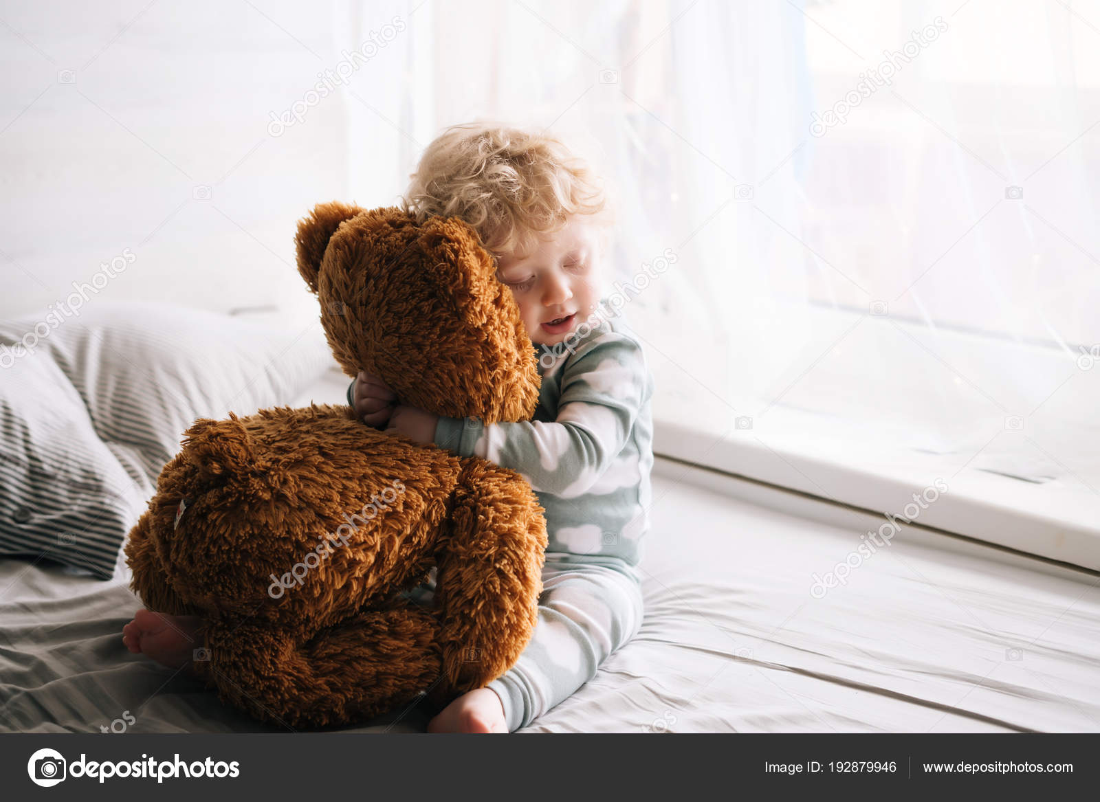 baby hugging teddy bear