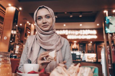 rahat bir oryantal kafede otururken, öğle yemeği ve gülümseyen bir başörtüsü güzel Arap kızla