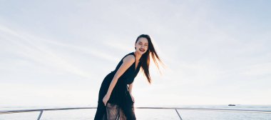 siyah yaz giysileri bir lüks mutlu kızı onun beyaz yatta duruyor gülümseyerek, adalarına yelken