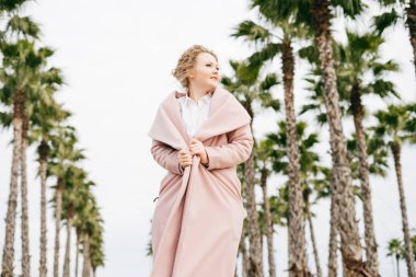 pembe ceket n kıvırcık kız şık güzel bahar parkta yürüyor, doğa ve sıcaklık sahiptir