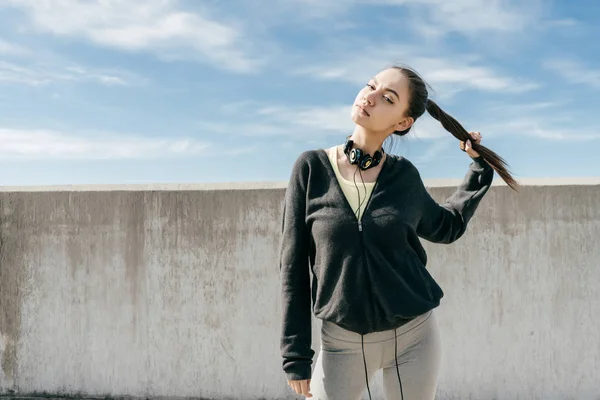 Stijlvolle jong meisje in sportkleding poseren buitenshuis, leidt een gezonde levensstijl — Stockfoto