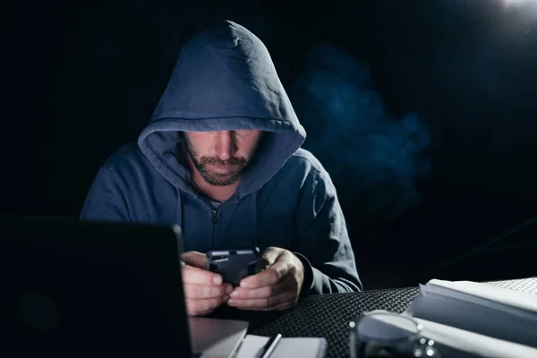 신비한 위험한 남성 해커 스마트폰, 후드에서에 비밀 번호를 해킹 — 스톡 사진