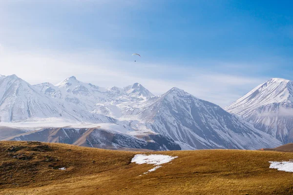 Uma natureza mágica, majestosas montanhas altas cobertas de neve branca, campos amarelos ilimitados — Fotografia de Stock