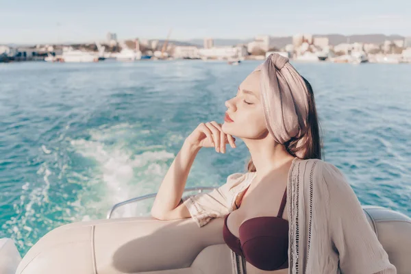 lüks bir zengin kızı deniz kenarında, onun beyaz yatta yelken tatil ve güneş sahiptir