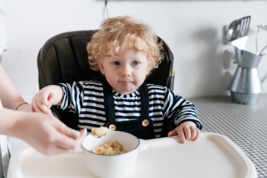 Anne bakım aile kahvaltı küçük kıvırcık çocuğuyla birlikte yararlı yulaf lapası beslemeleri