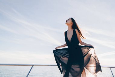 siyah yaz giysileri lüks bir genç kızı deniz yolculuğu zevk onun beyaz yatta duruyor