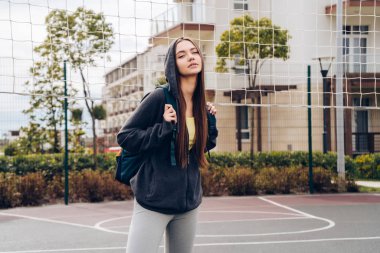 Kendine güvenen ince kız trenler, fitness açık spor alanı üzerinde çalışmaktadır, yarışmalar için hazırlar