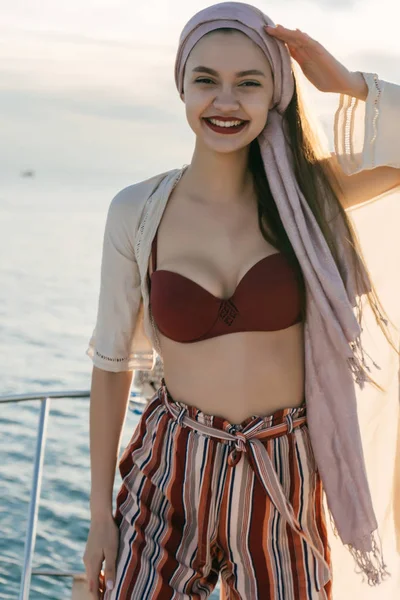 Onun beyaz yat üzerinde Karayip Adaları üzerinde gülümseyen genç kız trendy yaz pantolon içinde yüzüyor — Stok fotoğraf