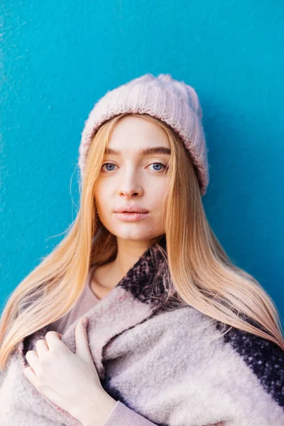 Junges blauäugiges blondes Mädchen mit Hut posiert draußen vor blauer Wand — Stockfoto