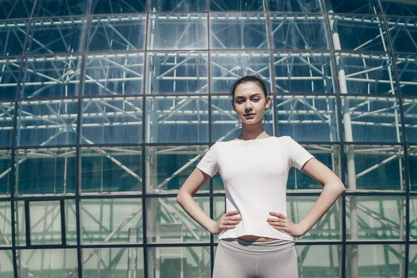 Kendine güvenen ince kız açık havada güneş altında trenler, güzel bir rakam istiyor