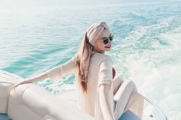 A luxurious rich woman with a headscarf on her head swims on her white yacht on the sea to the islands on vacation — Stock Photo, Image