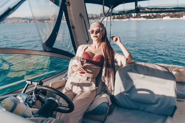 Una mujer joven de lujo disfruta de una rica vida y vacaciones, navega en un yate blanco blanco en el mar —  Fotos de Stock