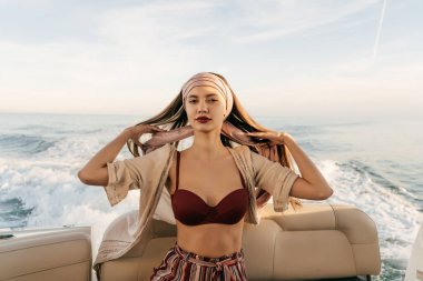 bir çekici lüks kız onun beyaz yatta oturur, adada bir tatil için zengin bir hayat yelken