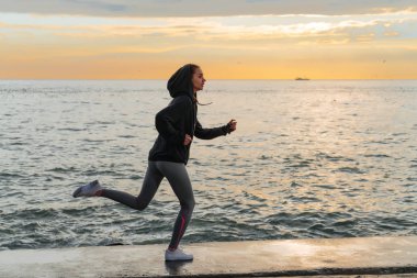 etkin güçlü kız Denizi çevresinde akşam çalışır, trenler, spor ve fitness seviyor