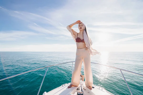 Luxurious attractive girl in stylish summer clothes posing on her white yacht in the sun, vacation — Stock Photo, Image