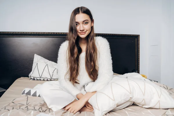Bonito de cabelos longos menina no pijama sentado na cama, quer dormir — Fotografia de Stock
