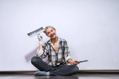 gülünecek bir genç kız onun yeni evinde katta oturur, spatula onun elinde tutan