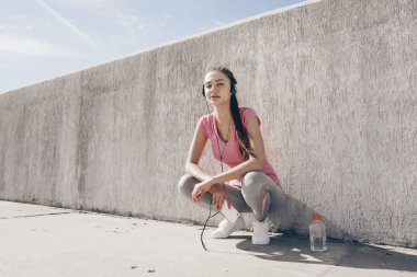 kulaklıklar müzik dinlemek, açık havada oturma, egzersiz yaptıktan sonra dinlenme güzel genç kız