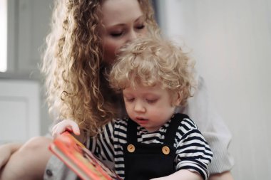 samimi bir aile, kıvırcık, sevecen bir anne genç çocuk oğlu ile oynuyor.