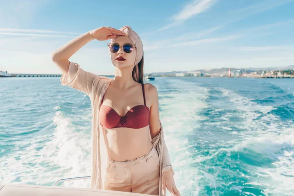 Una joven de lujo en gafas de sol nada en su yate blanco en el mar Caribe, mirando a la distancia —  Fotos de Stock