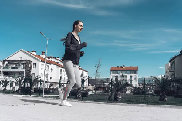 Сильна молода дівчина біжить на відкритому повітрі, займається фізичними вправами і втрачає вагу, готується до марафону — стокове фото