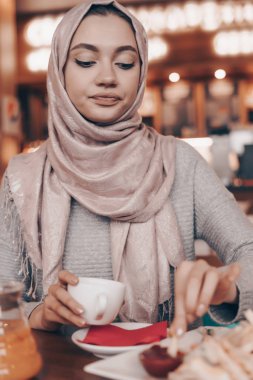 bir kafede içecekler kahve güzel oryantal kız başında başörtüsü ile akşam