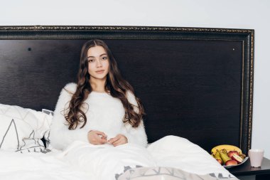 sevimli uzun saçlı kız yalan yatakta sert bir gün işten sonra dinlenme rahatlatır