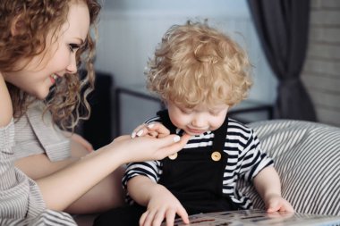 güzel genç anne gülümser, çalış genç çocuk oğlu ile öğretir okuma