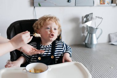 Anne oğlunu yararlı püresi ile besleme mutfakta, bir çocuğun sandalyede oturan küçük çocuk çocuk aile Kahvaltı