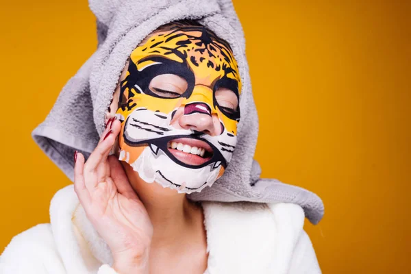 Krásná mladá dívka s šedou ručník na hlavě s úsměvem na tváři masku s tváří leopard — Stock fotografie