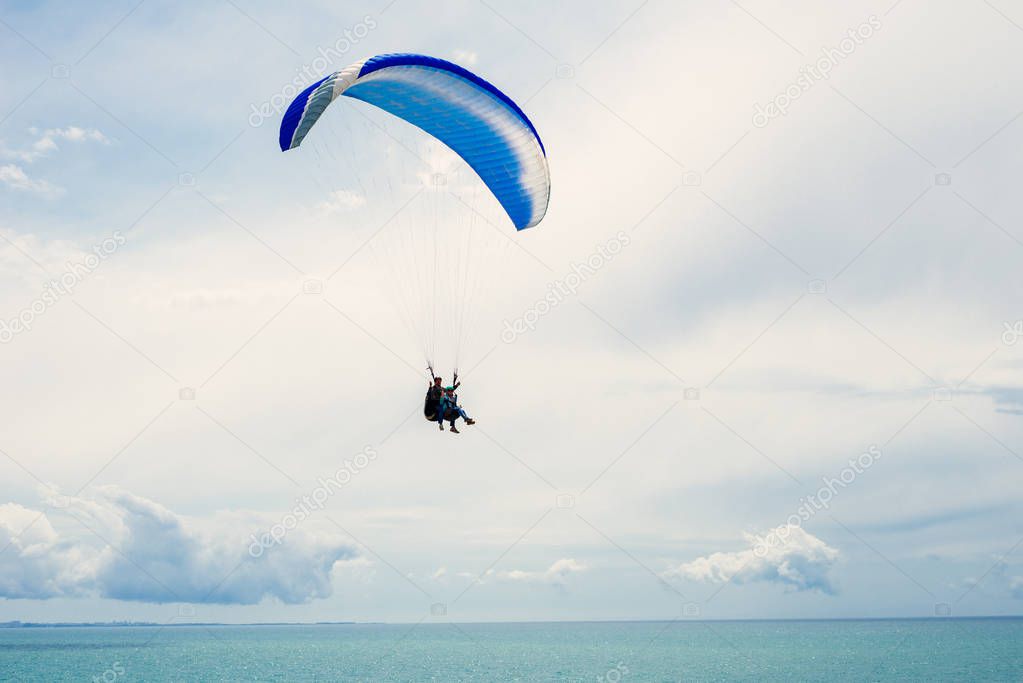 active people fly on an airplane across the sky over the sea, extreme sports