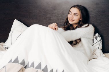 sevimli genç kız yatakta uyuyacak, bir şey hakkında hayal ve gülümseyen yalan söylüyor