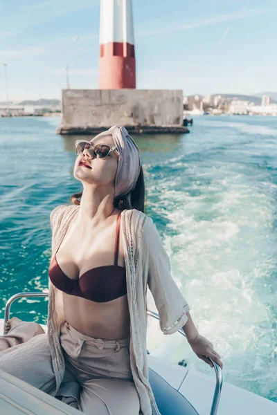 Eine ruhige junge Frau mit Sonnenbrille entspannt auf ihrer Jacht, segelt durch die Karibik — Stockfoto
