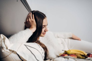 genç kız gülümseyerek ve dizüstü bilgisayarda ilginç bir film izlerken yatak yatarken pijama