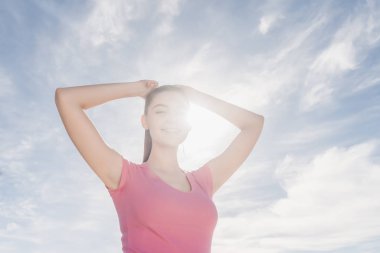 açık havada güneş altında duran, bir maraton için hazırlanıyor genç kız gülümseyerek